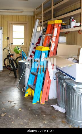 Intérieur d'un garage désordonné avec des vélos et des échelles et américain drapeau, boîtes et plus encore - mise au point sélective Banque D'Images