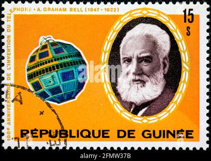 GUINÉE - VERS 1976 : un timbre imprimé en Guinée montre le portrait d'Alexander Graham Bell et du satellite Telstar, série, vers 1976 Banque D'Images