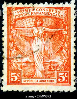 ARGENTINE - VERS 1921 : timbre-poste annulé imprimé par l'Argentine, qui montre une femme tenant des lettres devant un globe et promeut le 1er Pan-AME Banque D'Images