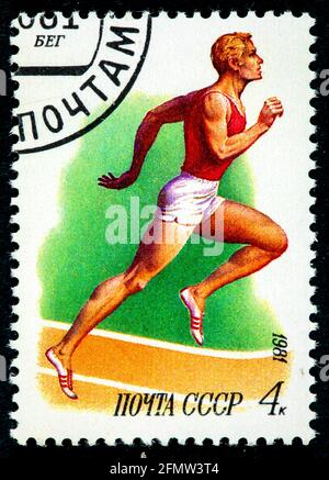 URSS - VERS 1981: Timbre imprimé en URSS, athlétisme de course, athlète masculin blanc en course à pied dans le stade, vers 1981 Banque D'Images