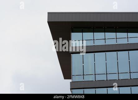 Installation de la construction de murs de fenêtres en verre dans un nouveau bureau générique construction contre un ciel blanc couvert Banque D'Images