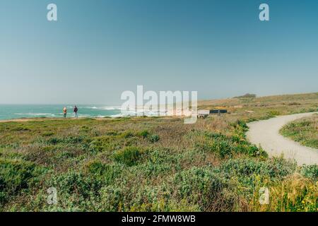 Montana de Oro, Californie-États-Unis, 8 mai 2021 piste de randonnée du parc national du Montana de Oro avec silhouette de personnes profitant de la vue sur l'océan, ciel bleu clair sur la ba Banque D'Images