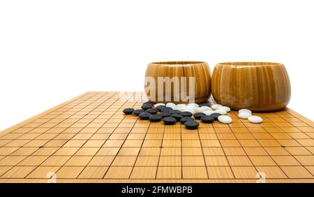 Jeu de Go isolé ou traditionnel chinois ancien jeu de société, pierres noires, pierres blanches et deux bols en bois sont mis à bord, bas angle et pers Banque D'Images