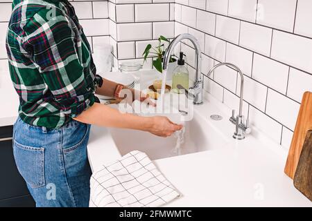 Une femme lave la vaisselle dans la cuisine Banque D'Images