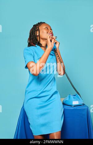 bonne fille secrétaire afro-américain émotionnellement parlant au téléphone Banque D'Images
