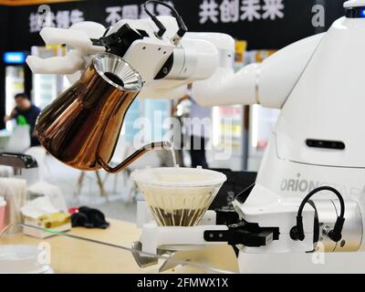 Guangzhou, Guangzhou, Chine. 12 mai 2021. Des robots chauffent l'eau à Guangzhou, Guangdong, le 11 mai 2021. 11 mai 2021, Guangzhou, Guangdong, voulez-vous boire une tasse de café faite par un robot pour vous? Au centre de congrès de Pazhou à Guangzhou, un robot de niveau maître faisait du café, attirant de nombreux exposants à regarder. Selon les rapports, ce robot de service peut faire 1 tasse de café en 5 minutes et convient pour des endroits tels que les supermarchés, les immeubles de bureaux, les endroits pittoresques ou les cafés. Crédit : SIPA Asia/ZUMA Wire/Alay Live News Banque D'Images