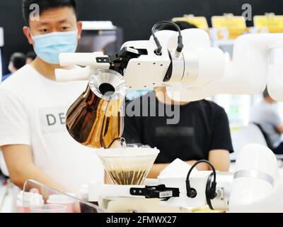 Guangzhou, Guangzhou, Chine. 12 mai 2021. Le 11 mai 2021, Guangzhou, Guangdong, les robots font du café pour attirer le public. 11 mai 2021, Guangzhou, Guangdong, voulez-vous boire une tasse de café faite par un robot pour vous? Au centre de congrès de Pazhou à Guangzhou, un robot de niveau maître faisait du café, attirant de nombreux exposants à regarder. Selon les rapports, ce robot de service peut faire 1 tasse de café en 5 minutes et convient pour des endroits tels que les supermarchés, les immeubles de bureaux, les endroits pittoresques ou les cafés. Crédit : SIPA Asia/ZUMA Wire/Alay Live News Banque D'Images