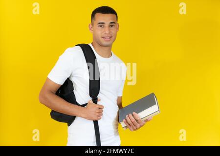 Heureux beaux livres de vacances d'étudiant isolés sur fond jaune. Banque D'Images