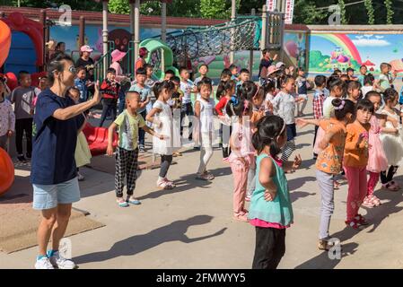 Les élèves de la maternelle qui pratiquent leur danse dans une école rurale de Shandong, en Chine. Banque D'Images