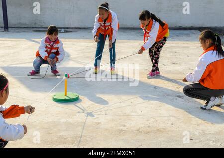 Les élèves du primaire de l'école murale de Qufu ont participé à une tâche de travail d'équipe pour déplacer le ballon sans le laisser tomber. Banque D'Images