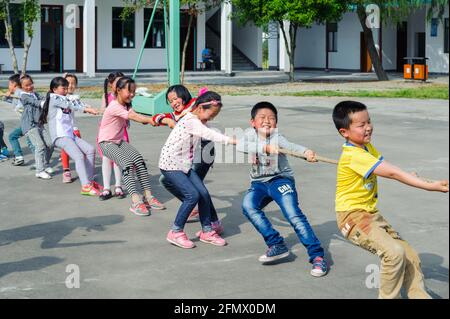 Des élèves de l'école primaire centrale de Weiqiao de Xiuning, Anhui, Chine participent à un concours de remorqueurs de guerre. Banque D'Images