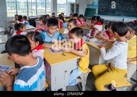 Des élèves de l'école primaire centrale de Weiqiao à Xiuning, Anhui, Chine apprennent des parties du corps en jouant au Bingo. Banque D'Images