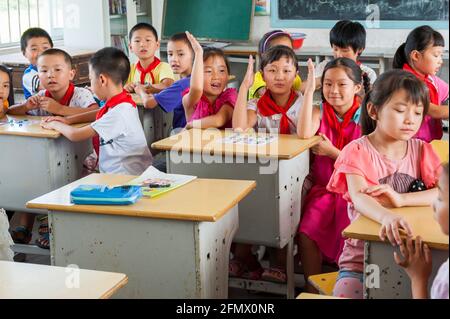 Des élèves de l'école primaire centrale de Weiqiao à Xiuning, Anhui, Chine apprennent des parties du corps en jouant au Bingo. Banque D'Images