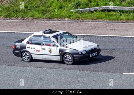 1999 90s années quatre-vingt dix Toyota Corolla modifié Yank American police car; UK voiture de circulation, transport, moderne, berline voitures, En direction du sud sur l'autoroute M61 à 3 voies. ROYAUME-UNI Banque D'Images