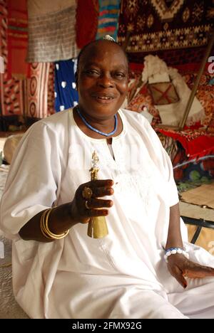 Osun Osogbo Fashion: Une main d'or, bracelets, bagues et Agogo. Banque D'Images