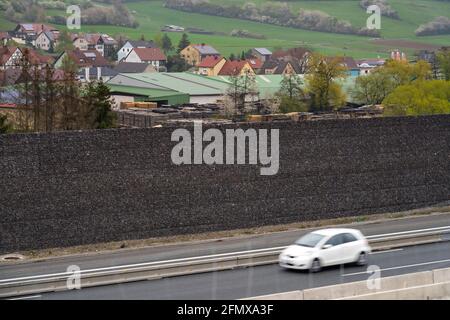 Geiselwind, Allemagne. 30 avril 2021. Une voiture passe devant le mur de gabion de la barrière anti-bruit près de Geiselwind sur l'autoroute A3. Credit: Nicolas Armer/dpa/Alay Live News Banque D'Images