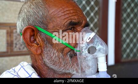 02 mai 2021 - Reengus, Sikar, Inde. Un vieil Indien portant le masque d'oxygène sur son visage. Masque d'asthme pendant la pandémie en Inde. Inhalation à la maison Banque D'Images