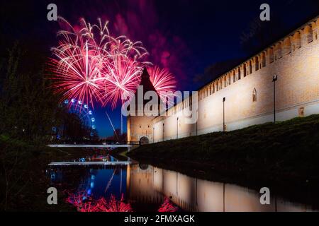 un festival de ville amusant se termine par un feu d'artifice festif. des explosions colorées de feux d'artifice dans le ciel du soir se reflètent dans l'eau Banque D'Images