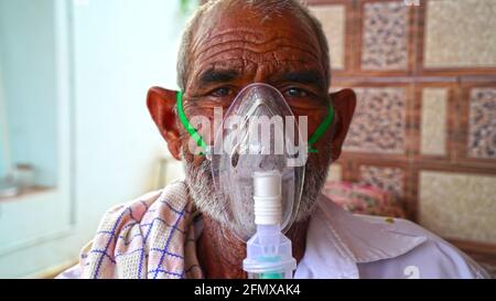 02 mai 2021 - Reengus, Sikar, Inde. Un vieil Indien portant le masque d'oxygène sur son visage. Masque d'asthme pendant la pandémie en Inde. Inhalation à la maison Banque D'Images