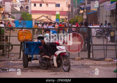 Phnom Penh, Cambodge. 12 mai 2021. Après 4 semaines de confinement total de la ville, le gouvernement a prolongé d'une semaine le confinement de la zone de couleur. Phnom Penh est mort dans 3 zones de couleur (rouge, orange et jaune) en raison de la vague de 19 de COVID. Un liveur attend en dehors d'une « zone rouge », ce qui signifie un risque élevé d'infection. De nombreux Cambodgiens sont en quarantaine dans leurs rues durant la pandémie du coronavirus. Credit: Kraig Lieb / Alamy Live News Banque D'Images