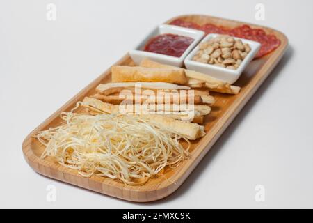 hors-d'œuvre de bière avec arachides, salami, toasts et fromage sur panneau de bois isolé Banque D'Images
