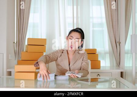 Une femme d'affaires tente de compter de l'argent dans la salle de bureau Banque D'Images