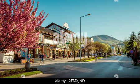 Ustron, Pologne - 11 mai 2021 : rue du centre-ville d'Ustron avec la montagne Czantoria en arrière-plan, Pologne. Banque D'Images