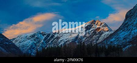 Vue panoramique avec lumière de l'heure d'or et ciel coloré lors d'une soirée d'hiver dans la vallée de Romsdalen, Rauma kommune, Møre og Romsdal, Norvège. Banque D'Images