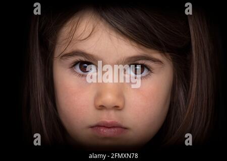 Portrait d'une jeune fille de quatre ans à l'aspect sérieux. Regard intense. Banque D'Images