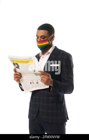 homme d'affaires afro-américain en couleurs lgbt masque médical lisant le journal isolé sur blanc Banque D'Images
