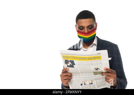 homme d'affaires afro-américain dans les couleurs lgbt masque de sécurité lisant le journal isolé sur blanc Banque D'Images