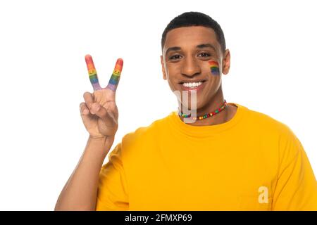 homme américain africain positif avec drapeau lgbt peint sur le visage signe de paix isolé sur blanc Banque D'Images
