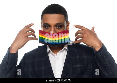 african american gay homme d'affaires mettant sur le masque médical en lgbt couleurs isolées sur blanc Banque D'Images