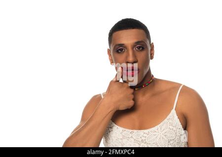 homme afro-américain en sous-main regardant la caméra tout en se matraquant rouge à lèvres isolé sur blanc Banque D'Images