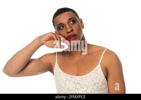 afro-américain transvestite homme dans la sundress touchant le visage tout en regardant isolé sur blanc Banque D'Images