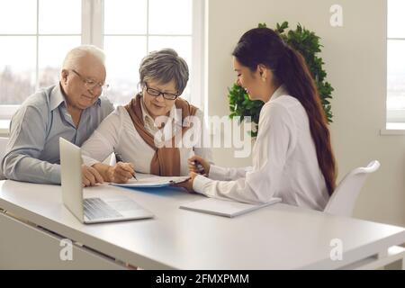 Un couple de familles mariées âgées signe un contrat avec le directeur de banque réunion Banque D'Images