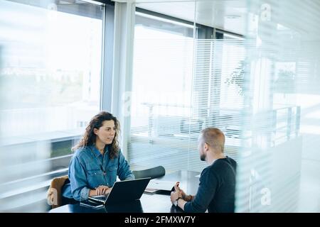 femme d'affaires interviewant le candidat à l'emploi masculin dans la salle de réunion. Homme assis dans une salle de conférence pour un entretien d'embauche. Banque D'Images