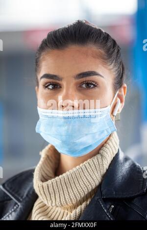 Une femme voyageant dans les transports publics portant son masque facial de la mauvaise manière, il ne couvre pas son nez. Banque D'Images