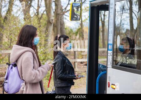 Deux jeunes femmes attendent à un arrêt de bus dans le rue Banque D'Images