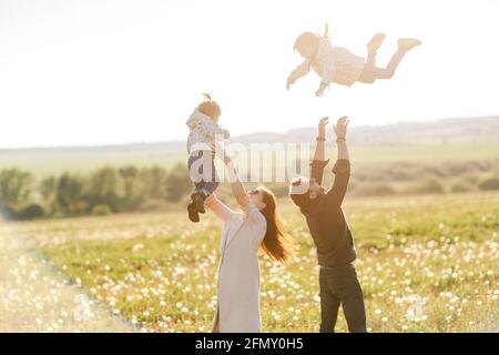 promenades en famille dans la nature. Maman et papa lancent leurs enfants Banque D'Images