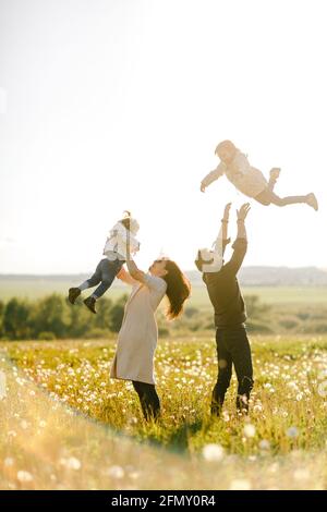 promenades en famille dans la nature. Maman et papa lancent leurs enfants Banque D'Images