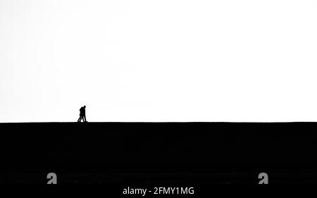 Noir et blanc, Monochrome de deux personnes marchant ensemble sur le Skyline horizon style minimaliste Royaume-Uni Banque D'Images