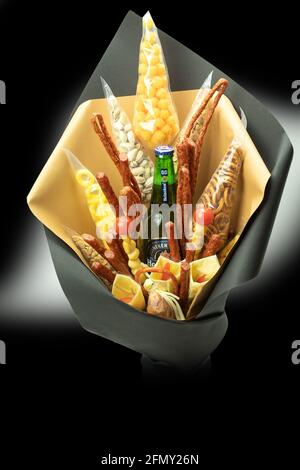 Varsovie, Pologne - 26 avril 2021 : bouquet alcoolique, un cadeau original pour un homme. Bouquet de viande et de fromage. Bouquet de saucisses, légumes, fromage, brea Banque D'Images