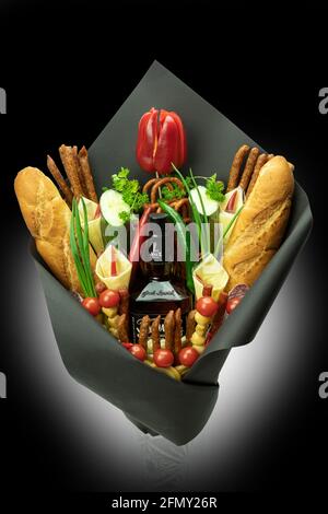 Varsovie, Pologne - 26 avril 2021 : bouquet alcoolique, un cadeau original pour un homme. Bouquet de viande et de fromage. Bouquet de saucisses, légumes, fromage, brea Banque D'Images