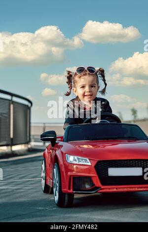 Une fille à bord d'une voiture-jouet Banque D'Images