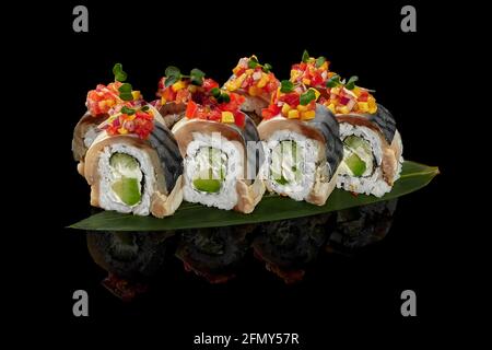 Rouleaux avec filet de maquereau sur feuille de bambou sur fond noir Banque D'Images