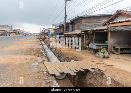 L'aménagement d'une nouvelle canalisation en tranchée à travers la ville, Paksong, Laos Banque D'Images