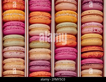 Vue de dessus des macarons colorés dans les rangées dans la boîte Banque D'Images