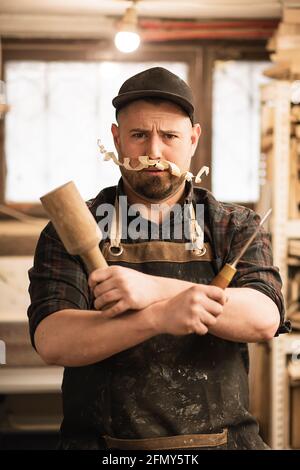 portrait amusant en gros plan de menuisier avec des copeaux de moustache et des outils Banque D'Images