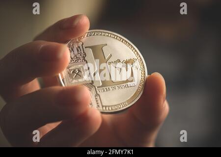 Litecoin de crypto-monnaie en main dans le cadre de la conclusion d'affaires Banque D'Images